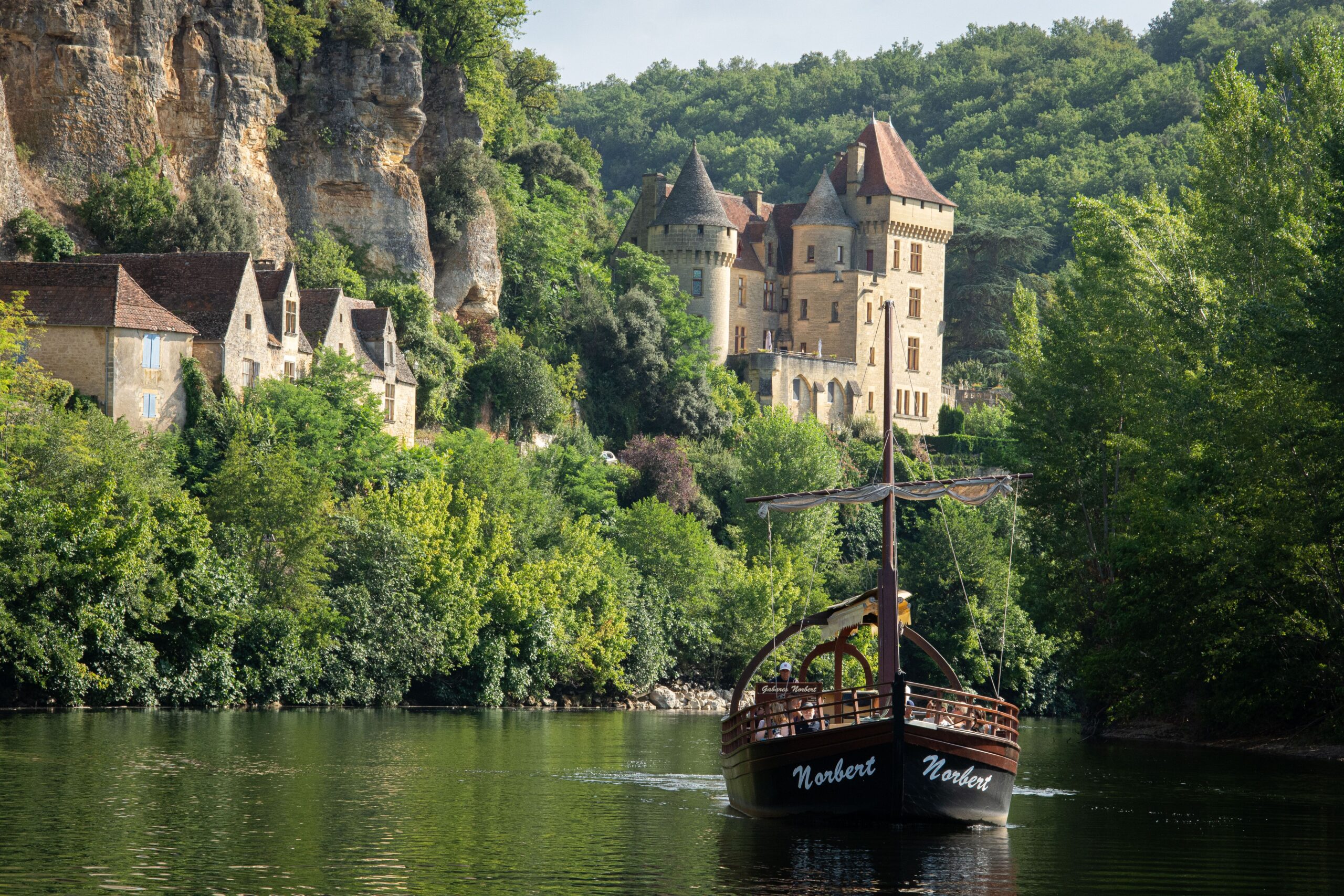 Bateau sur la rivière Dordogne près d'un château médiéval